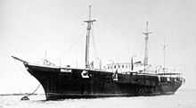 A steamship anchored to a mooring buoy with other ships in the distance