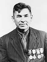 older man with suit, tie, and medals on his chest