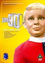 The face of a young, blond-haired boy is to the right of the image, while the left side is dominated by bold, silver lettering which forms the words "Joe 90". The background is yellow.