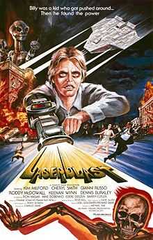 A film poster with a young man with a laser gun extended from his arm, shooting out the title "Laserblast". A tagline at the top reads "Billy was a kid who got pushed around... Then he found the power". The top left shows two extra-terrestrial aliens on top of a burning building, opposite an extra-terrestrial spacecraft. Below the burning building, people are seen running away on the street. Credits for the film appear below the title, and a skeleton on fire is at the bottom of the image.