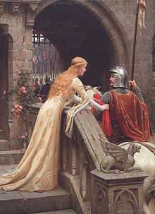 A young woman in a medieval-style dress of cream satin ties a red scarf to the arm of a man in armour and mounted on a horse. The scene is set at the portal of a castle.