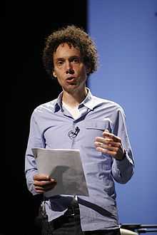 A man holds a piece of paper while he gives a speech