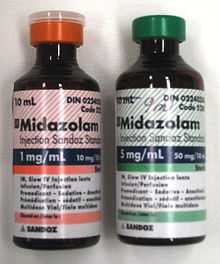 Two 10 ml bottles labeled Midazolam  - the bottle on the left has a label in red and says 1 mg/ml; the one on the right is in green and says 5 mg/ml. Both bottles have much fine print.