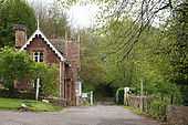 Gateway between trees, with a house on the left