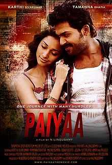 A poster of the film, Paiyaa. A woman, wearing a violet dress, is resting her head on a man's right shoulder and touching his coat with her right arm. The man is wearing a white shirt with an eagle symbol on it and a striped jacket. The film's has a caption "One journey with many hurdles." Below it are the credits of the cast and crew, in red text.