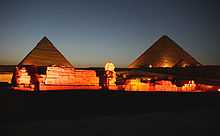 A complex of ruins, including two pyramids and the statue of the Sphinx.