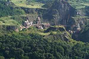 View of a mountainside with steep cliffs and domed structures built on the ledges.