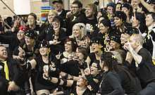 Roller derby skaters and supporters celebrating.