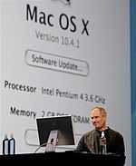 Man in black shirt conducting onstage computer demonstration