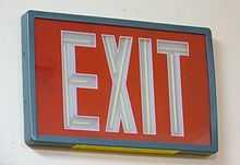 A photo of a self-luminous exit sign that contains tubes of tritium