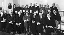 A large group of white men in suits posing for a picture