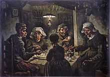 group of five sit around a small wooden table with a large platter of food, while one person pours beverages from a kettle in a dark room with an overhead lantern