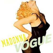 A blond woman poses with her head leaning back, wearing a black corset. Alongside her, the word "Madonna" is written in yellow capital letters, and just underneath this, to its side, "Vogue" is also written in bigger, grey capital letters.