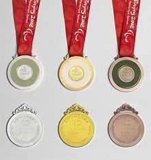 Six medals are shown to display the front and back of each. From left to right, silver, gold and bronze.