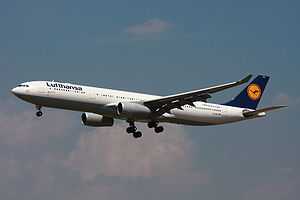 A white, blue, yellow and grey Lufthansa A330 on approach, configured for landing with gears down and flaps extended