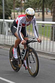 A cyclist wearing a skinsuit and riding an aerodynamic bike.