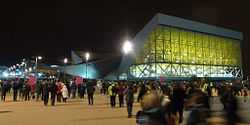 Night view of modern building, with many people walking outside