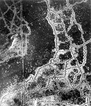An aerial reconnaissance photograph of the opposing trenches and no man's land between Loos and Hulluch in Artois, France . German trenches are at the right and bottom, and British trenches are at the top left. The vertical line to the left of centre indicates the course of a pre-war road or track.