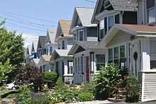 Two-story, single-family homes line a street; the houses are identical in design except for color.