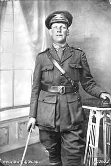 A studio portrait of a military officer in full uniform with cane.