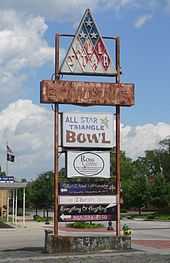 Faded and rusting sign in parking lot: at top, triangular sign with "All Star"; below that, very faded "Bowling"; below that, "All Star Triangle Bowl"; below that, fresher signs with names of current tenants: Ross Centre, The Word Ministry, The Thrift Store, Everything & Anything, and the phone number 803-534-4550