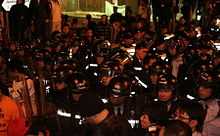 A tightly-bundled group of police officers in riot gear assembled in Jackson Road