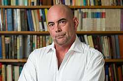 Donald Antrim in front of a bookcase.