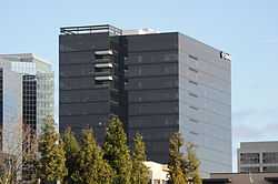 A dark modernist building with a glass curtain wall facade