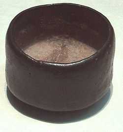 Photo of a tea bowl, dark-coloured, humble, and asymmetric.