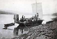 Prospectors sailing toward Dawson in boat on upper Yukon River, 1898