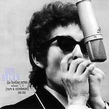 A black-and-white photograph of Dylan playing harmonica