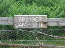 wooden sign on a fence, reading "BP's 1907 CAMP SITE"