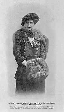 Three-quarter length portrait photograph of Natalia wearing an Edwardian-style dress and hat with furs