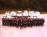 A fire department group photograph showing members and vehicles