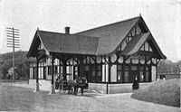 A Tudor Revival train station with a horse and buggy