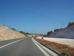 A completed two-lane carriageway and earthworks completed for a parallel carriageway