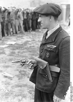Man in uniform, wearing a beret and holding a revolver