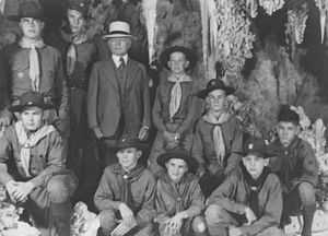 Photograph of Burnham in 1941 celebrating his 80th birthday with several boy scouts.  All of them are posing in Carlsbad caverns. The boys are dressed in their boy scout uniforms.  Burnham is dressed in a full suit and tie and wearing a white hat.