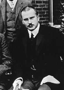 A black and white image of Carl Jung, wearing formal clothing.