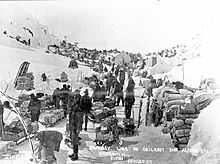 Klondikers and their supplies at US-Canadian border line on Chilkoot Pass, 1898