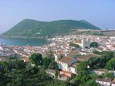 Coastal town with white houses and churches with red roofs
