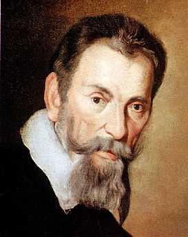  Head of a heavily bearded short-haired man with a serious expression, leaning slightly forward and facing semi-right, although his eyes look straight ahead. A white collar over a dark coat or cloak is also visible.