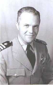 portrait photograph of a man wearing the uniform of an officer of the United States Navy, with the rank of commander.