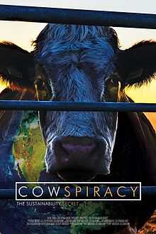 A movie poster showing a cow with a sunset in the background