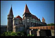 A castle built of stone with at least three towers and a dozen windows