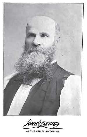 Bald man in white shirt and dark vest, with beard