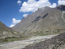 Village on a river at the foot of a mountain range