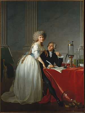 Full-length portraits of a man and a woman. The man is seated at a table covered with a bright red cloth, looking up at the woman, and she is looking out at the viewer. They occupy the bottom half of the painting, while the top half resembles marble and pillars. She is wearing a white dress with a blue sash and he is wearing a dark coloured suit. Glass chemistry equipment sits on the table and on the floor.
