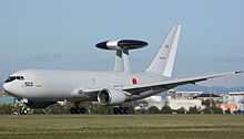 Side view of Japan military reconnaissance aircraft on airport runway, with dorsal mounted sensor pallet.