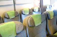 Airline premium economy cabin. Rows of seats arranged between aisles.